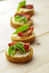 Tasty  bruschetta with sun-dried tomatoes on wooden table