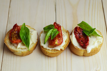 Tasty  with sun-dried tomatoes on wooden table