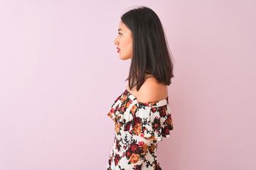 Young chinese woman wearing floral t-shirt standing over isolated pink background looking to side, relax profile pose with natural face with confident smile.