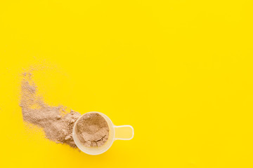 Sport diet with protein powder on yellow background top view copyspace
