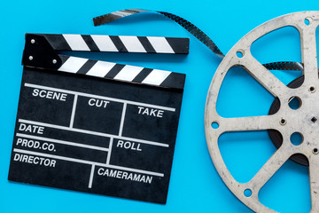 Go to the cinema with film type and clapperboard on blue background top view
