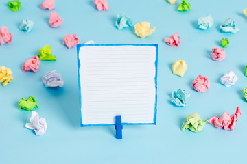 Colored crumpled papers empty reminder blue floor background clothespin