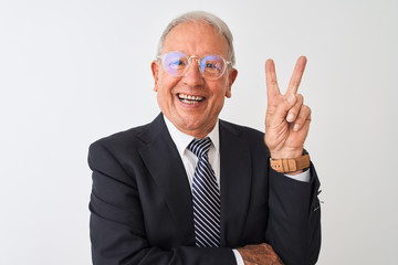 Senior grey-haired businessman wearing suit and glasses over isolated white background smiling with happy face winking at the camera doing victory sign. Number two.