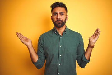 Young indian businessman wearing elegant shirt standing over isolated white background clueless and...