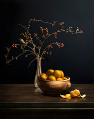 Still life composed of Asiatic bittersweet branches with fruit, vase, bowl of clementinesff