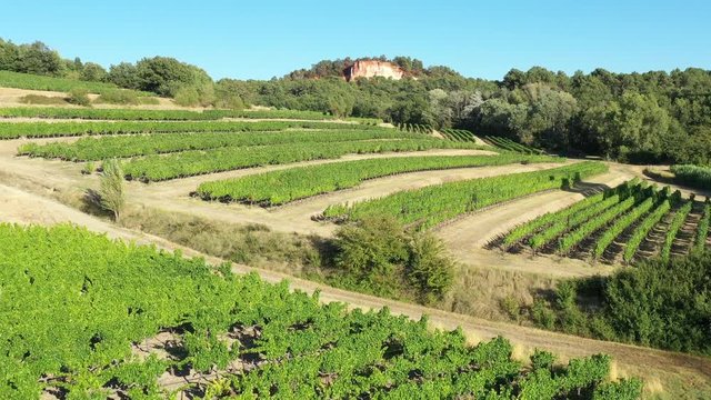 aerial sunny day over vineyards fields and ochre quarries Roussillon village France Vaucluse Luberon