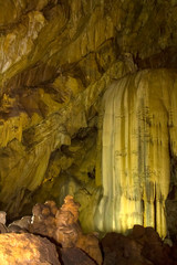 yellow stalactites in a cave. The formation of stalactites on the ceiling of the cave