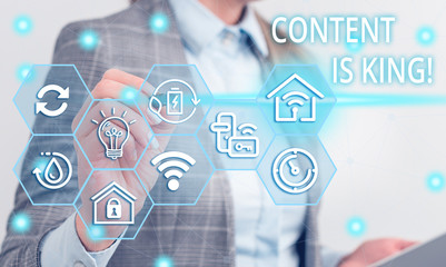 Writing note showing Content Is King. Business concept for marketing focused growing visibility non paid search results Female human wear formal work suit presenting smart device