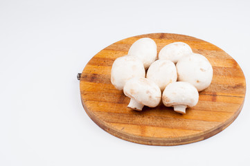 Mushrooms on wooden board isolated on white background. Healthy food.Copy space