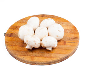 Mushrooms on wooden board isolated on white background. Healthy food.Copy space