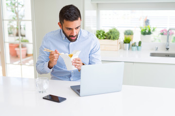Business man eating asian food from delivery while working using computer laptop at the office