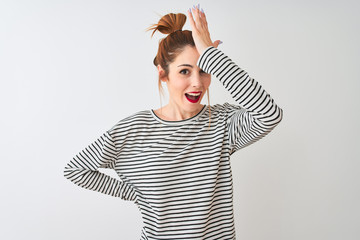 Redhead woman wearing navy striped t-shirt standing over isolated white background surprised with...