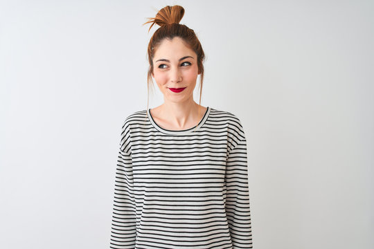 Redhead woman wearing navy striped t-shirt standing over isolated white background smiling looking to the side and staring away thinking.