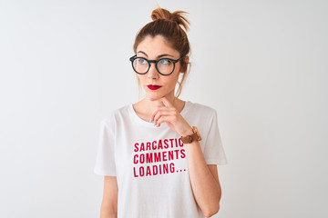 Redhead woman wearing funny t-shirt with irony comments over isolated white background serious face...