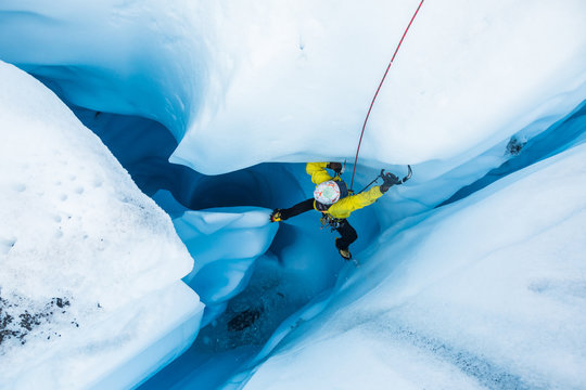 Ice climber stemming off a vertical pillar of ice inside a moulin on the Matanuska Glacier. - Powered by Adobe