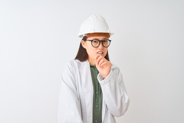Young chinese engineer woman wearing coat helmet glasses over isolated white background disgusted...