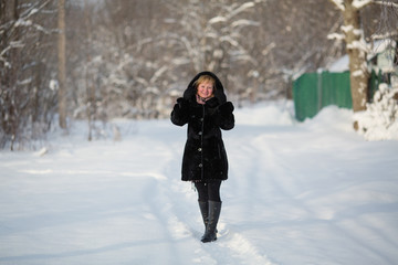 Fototapeta na wymiar Young woman at winter in the snowy Park.