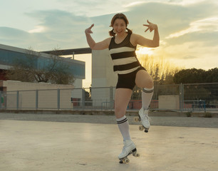 Woman skating and having fun in the city with four-wheel skates. Skating and dancing at sunset