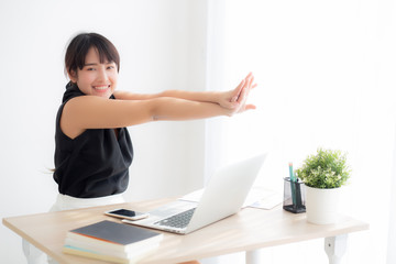 Obraz premium Beautiful portrait asian woman stretching muscle arms after working with laptop for protect office syndrome with relax, asia girl leisure and exercise because tired, business and healthy concept.