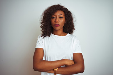 Young african american woman wearing t-shirt standing over isolated white background skeptic and nervous, disapproving expression on face with crossed arms. Negative person.