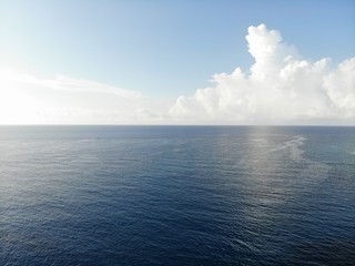 Still blue sea ocean with sky and clouds in background