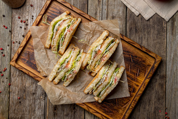 Club Sandwich mit Hühnchen auf Holzbrett