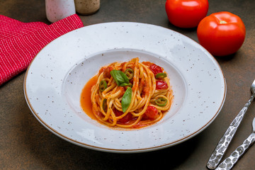 Pasta spaghetti arabiata on dark rustic background