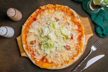 Pizza Caesar on plate on dark rustic background