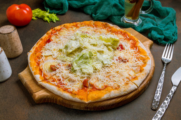 Pizza Caesar on plate on dark rustic background