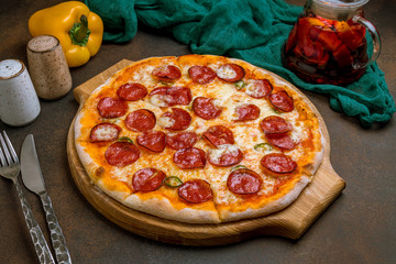 Pepperoni pizza on plate on dark rustic background