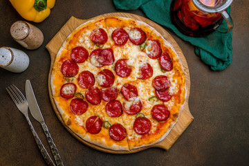 Pepperoni pizza on plate on dark rustic background