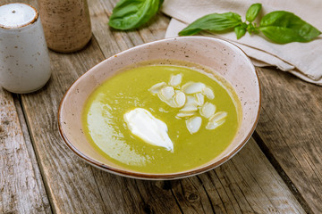 Cream of broccoli soup on old wooden table