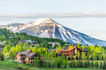 Mount Crested Butte, Colorado village in summer with colorful sunrise by wooden lodging houses on...