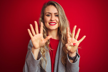 Young beautiful business woman wearing elegant jacket standing over red isolated background showing...