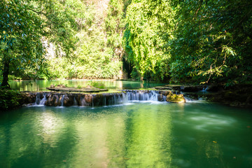Waterfall in deep tropical rainforest with green tree