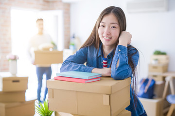 Beautiful young asian couple looking happy, young woman smiling excited moving to a new home