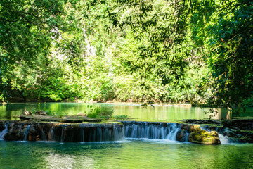 Waterfall in deep tropical rainforest with green tree