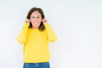 Obraz na płótnie Canvas Beautiful middle age woman wearing yellow sweater over isolated background Smiling pulling ears with fingers, funny gesture. Audition problem