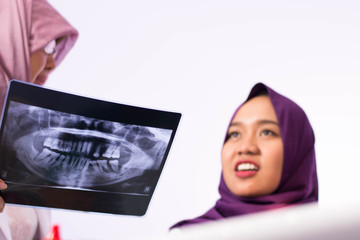 Portrait of two hijab muslim woman dentist and patient discuss something and dentist clinic