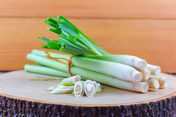 Fresh lemongrass rope and lemongrass slice on wooden cutting board in cooking concept.