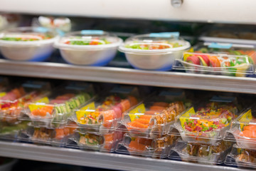 Fresh sushi for sale at a supermarket deli in togo containers
