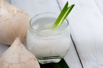 Fresh coconut juice in a glass with coconut white meat isolated on white