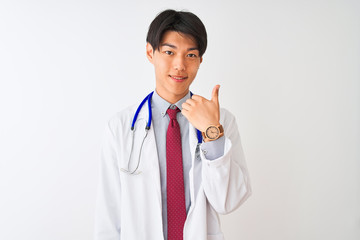 Chinese doctor man wearing coat tie and stethoscope over isolated white background doing happy thumbs up gesture with hand. Approving expression looking at the camera with showing success.