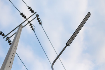 Street light and electric poles on the sky background