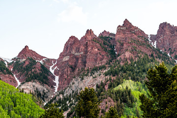 Maroon Bells red cliffs closeup in Aspen, Colorado during blue hour cloudy dawn before sunrise with rocky mountain peak in early summer