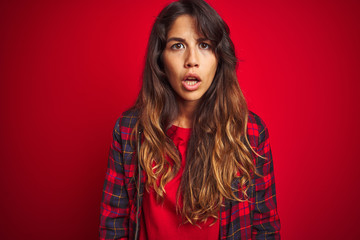 Fototapeta premium Young beautiful woman wearing casual jacket standing over red isolated background relaxing and stretching, arms and hands behind head and neck smiling happy