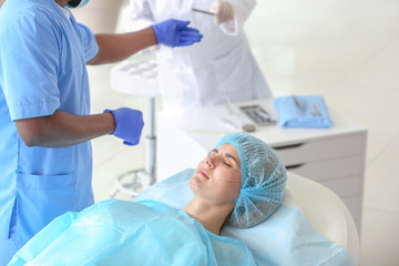 Plastic surgeon preparing woman for operation in clinic