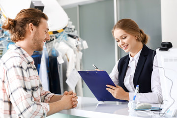 Client near reception desk of modern dry-cleaner's