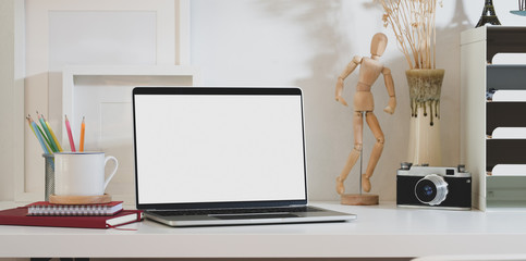 Blank screen laptop computer with office supplies