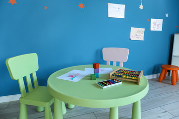 Table with abacus and kid's drawing in kindergarten